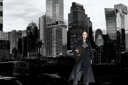 Model in schwarz vor Skyline